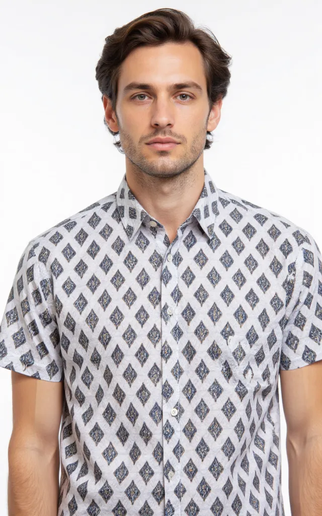 A French model wearing a Diamond pattern   printed shirt, against a white background, in a front   facing bust portrait